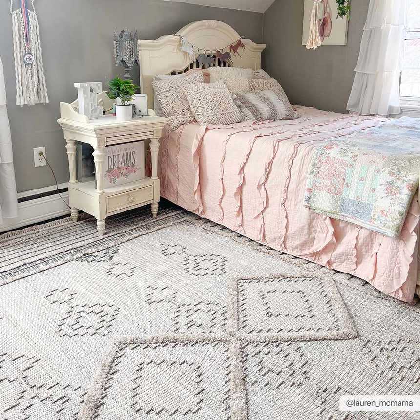 Light and airy bedroom with pink bedding and the Amaga High-Low Rustic Rug in cream and charcoal. Roomscene-Rectangle
