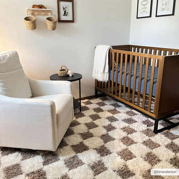 Nursery with white glider, crib, and the Atira Brown Checkered Area Rug adding a cozy, geometric touch. Roomscene-Rectangle