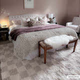 Bedroom scene with the Atira Light Brown Checkered Area Rug. Pink walls, white bedding, and a cozy, inviting mood. Roomscene-Rectangle