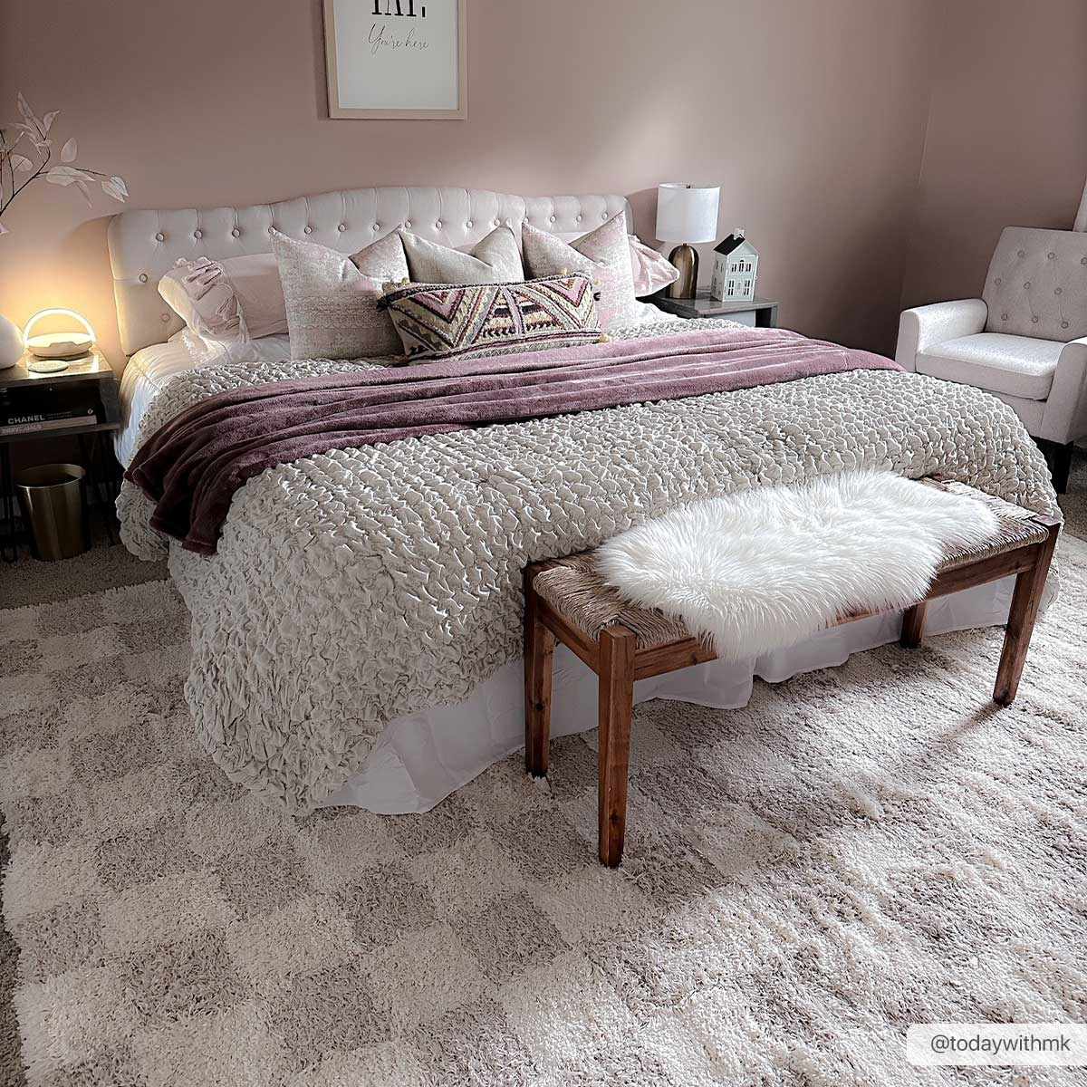 Bedroom scene with the Atira Light Brown Checkered Area Rug. Pink walls, white bedding, and a cozy, inviting mood. Roomscene-Rectangle