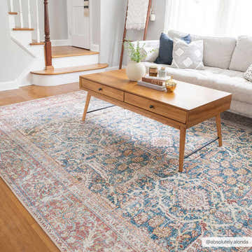 Living room scene with Avel Washable Area Rug in beige, blue, and burgundy. Oriental rug under a wood coffee table, neutral sofa. Roomscene-Rectangle