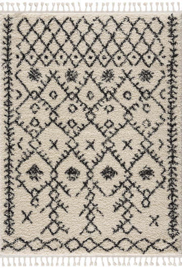 Close-up of the Godalming Plush Area Rug. Beige shag rug with charcoal Moroccan-inspired diamond pattern and tassels. Design-Rectangle-5373