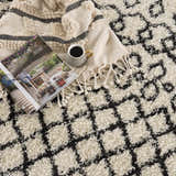 Close-up of the Muni Berber Shag Rug in charcoal and light beige with a geometric Moroccan-inspired design and soft, shag texture. Styleshot