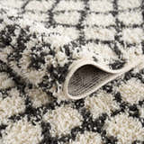 Close-up of the Muni Berber Shag Rug, showcasing its charcoal and light beige colors and plush, textured shag design. Fold