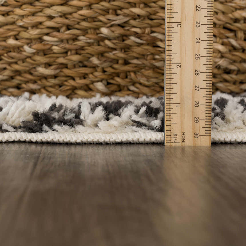 Close-up of the plush texture and pile height of the Muni Berber Shag Rug in charcoal and light beige. Pile