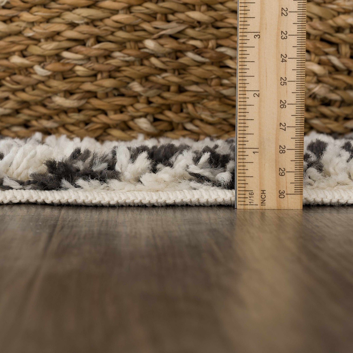 Close-up of the plush texture and pile height of the Muni Berber Shag Rug in charcoal and light beige. Pile