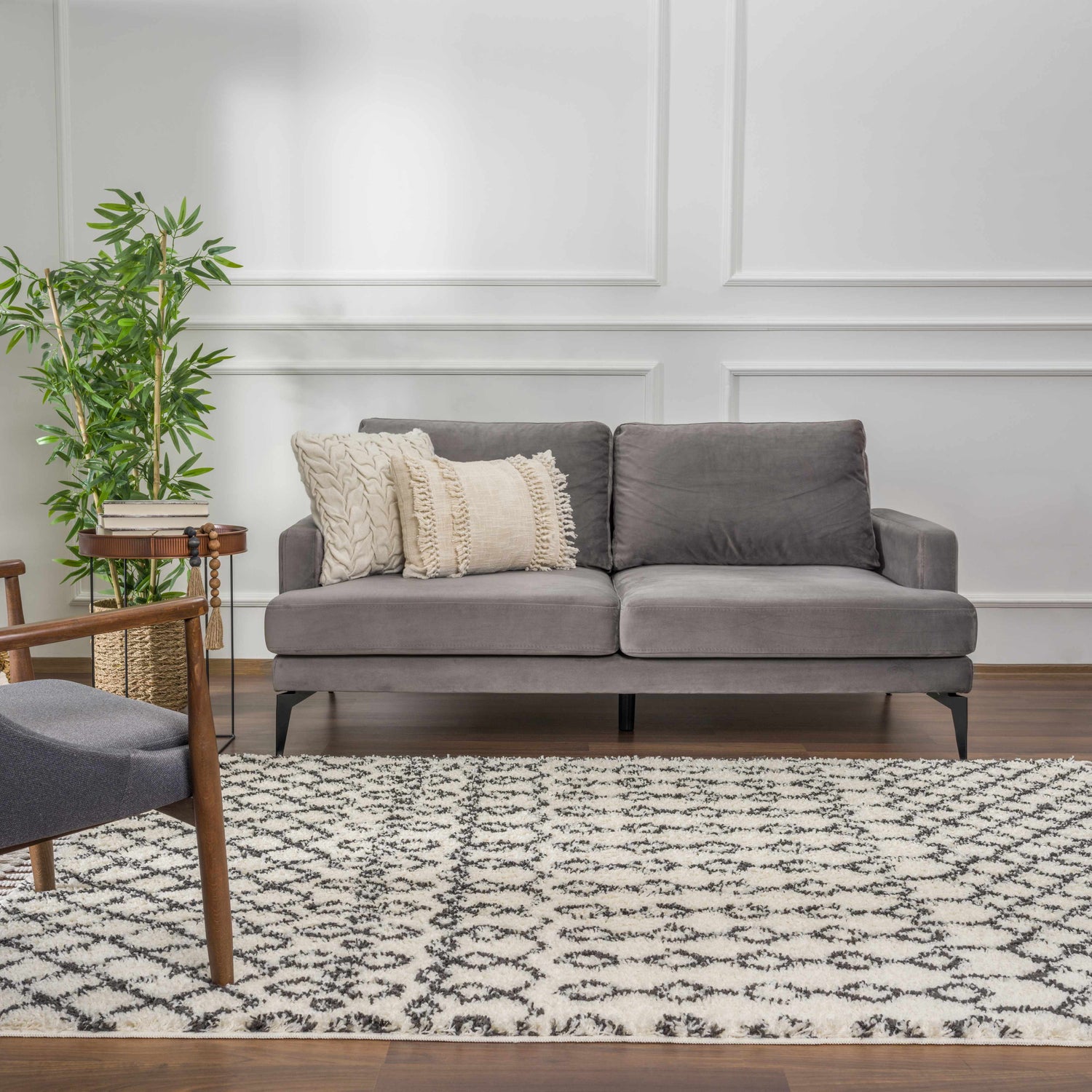 Living room scene with gray sofa, wood chair, and Muni Berber Shag Rug in charcoal and light beige on hardwood floor. Roomscene-Rectangle