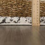 Close-up of the bone and dark gray Howth Area Rug showing its shag texture and height with a ruler. Pile