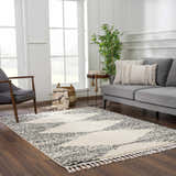 Living room scene with gray sofa, chair, and Howth Area Rug in bone and dark gray with a Moroccan shag design. Roomscene-Rectangle
