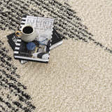 Close-up of the bone and dark gray Howth Area Rug, a shag rug with a Moroccan-inspired geometric pattern. Styleshot
