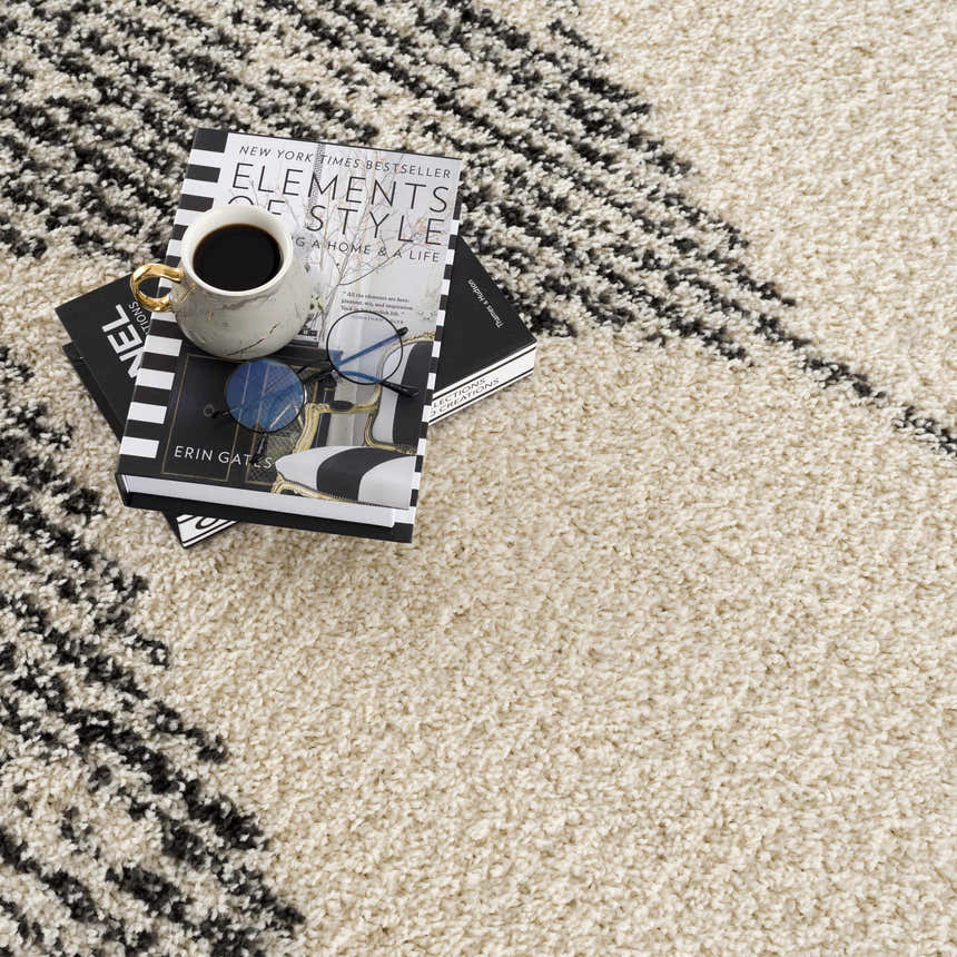 Close-up of the bone and dark gray Howth Area Rug, a shag rug with a Moroccan-inspired geometric pattern. Styleshot