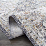 Close-up of the machine-woven Ivria Navy & Rust Area Rug, showing its light gray, natural gray, rust, and navy farmhouse pattern. Fold