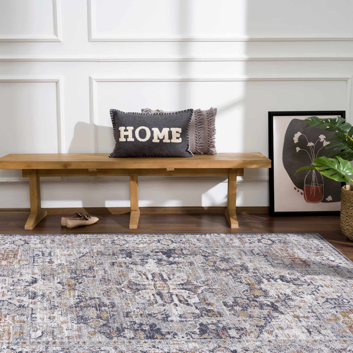 Entryway scene with wood bench, plant, and Ivria Navy & Rust Area Rug in light gray, navy, and rust colors. Roomscene-Rectangle