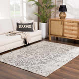 Living room scene with a Paicines Area Rug in charcoal and gray, styled with a white sofa, wood cabinet, and potted plant. Roomscene-Rectangle