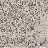 Close up of the Paicines Area Rug, a charcoal and light beige rug with a traditional, vintage pattern and subtle texture. Texture