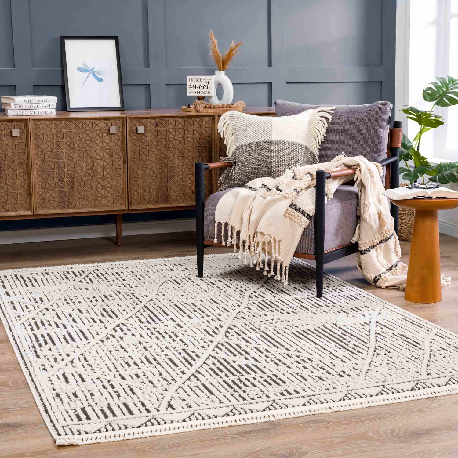 Living room scene with Umay Textured Beige Rug, gray chair, wood cabinet, and neutral decor. Roomscene-Rectangle