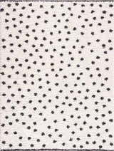 Close-up of the Chaia Dotted Black & White Plush Rug, featuring a soft texture and playful black polka dot pattern on a white base. Design-Rectangle-5373
