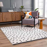 Living room scene with a Chaia Dotted Black & White Plush Rug, gray chair, and wood cabinet. Contemporary style. Roomscene-Rectangle