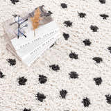 Close-up of the Chaia Dotted Black & White Plush Rug, a shag rug with a black dotted pattern on a soft, white textured background. Styleshot