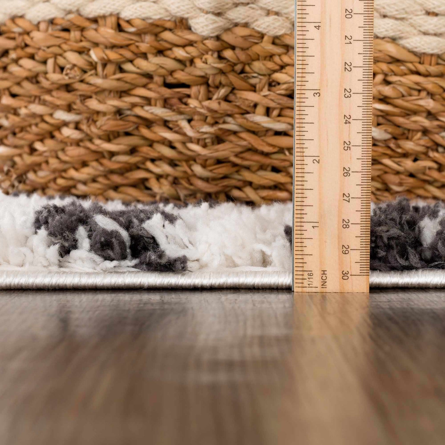 Close-up of Zhen Black Spots Leopard Rug showing shag texture, black and white pattern, and rug thickness with a ruler. Pile