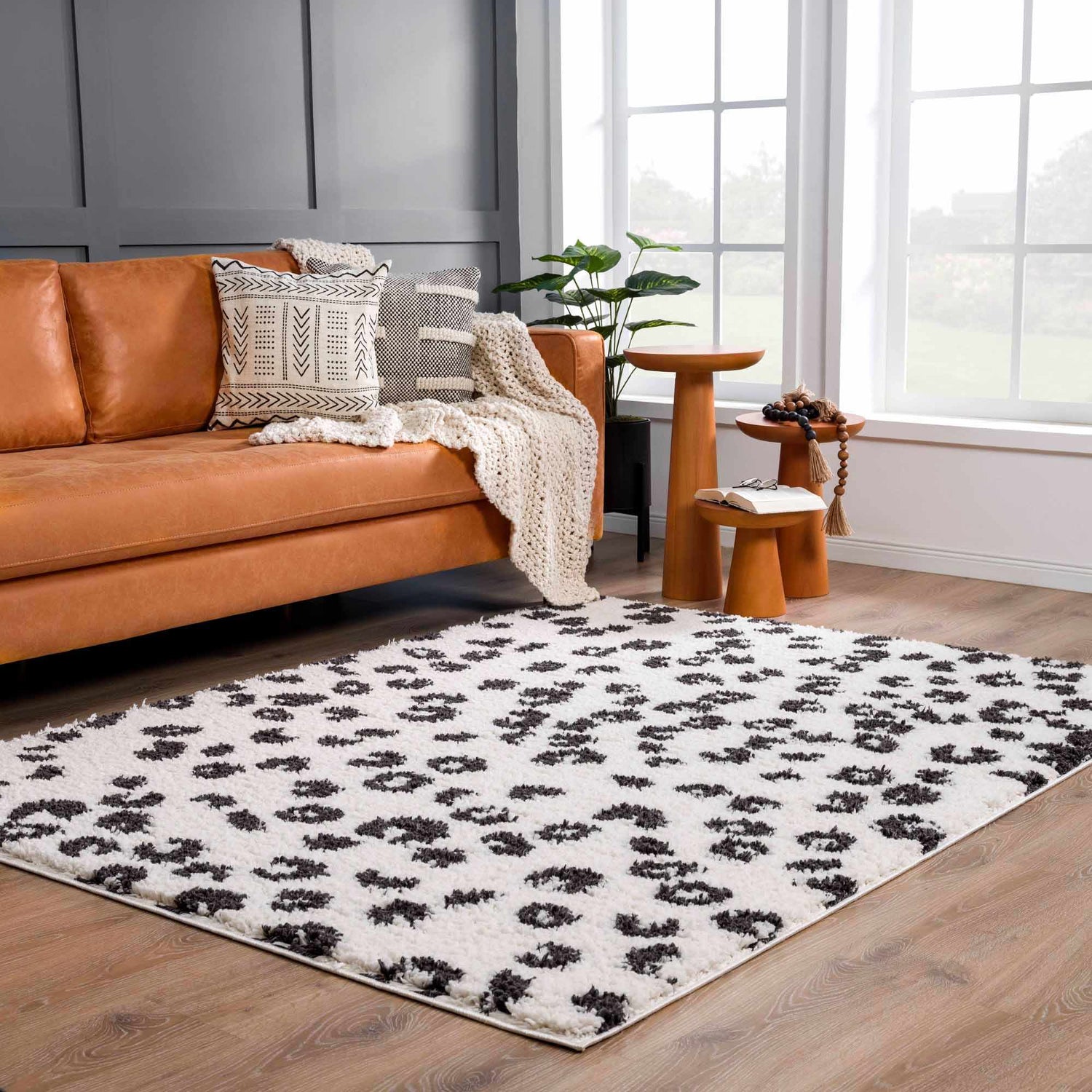 Living room with a tan leather sofa and the Zhen Black Spots Leopard Rug. Roomscene-Rectangle