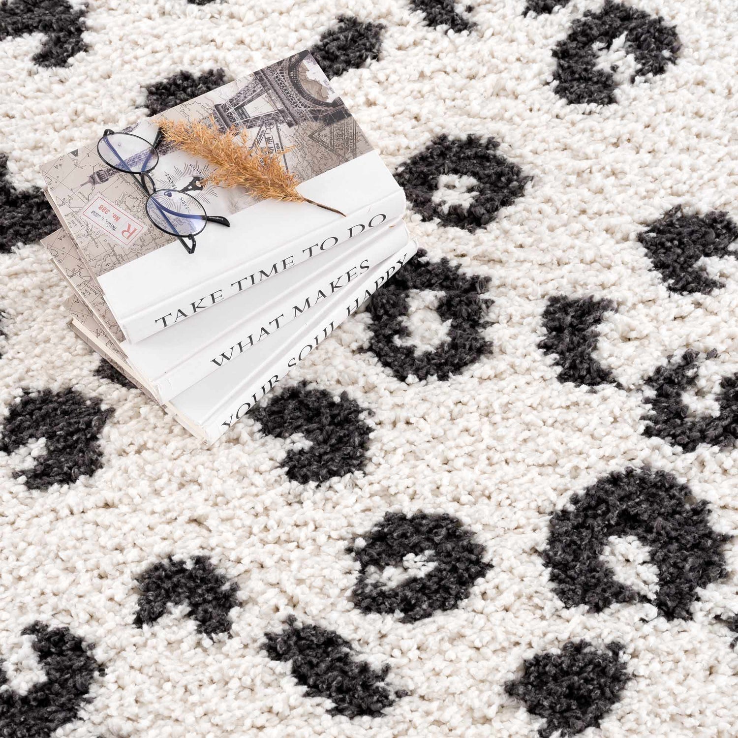 Close-up of the Zhen Black Spots Leopard Rug, a shag rug with a black and white leopard print pattern. Styleshot