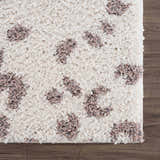 Close-up of a Zhen Pink Spots Leopard Rug showing its shaggy texture and brown, off-white, and pink leopard spots. Swatch