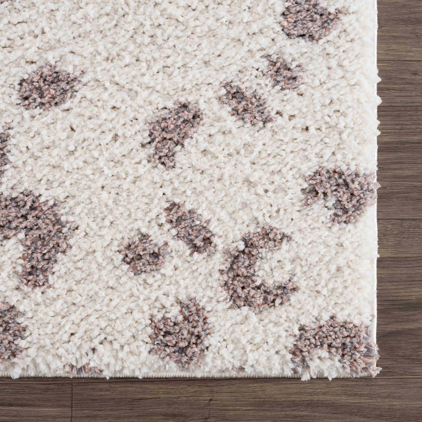 Close-up of a Zhen Pink Spots Leopard Rug showing its shaggy texture and brown, off-white, and pink leopard spots. Swatch