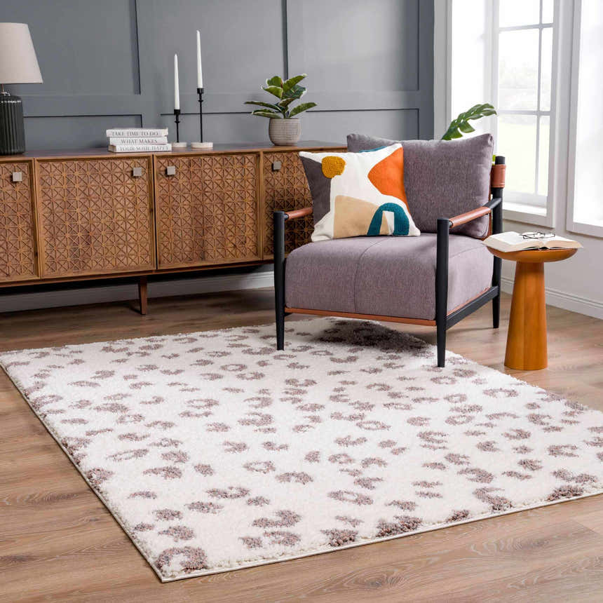 Living room scene with a Zhen Pink Spots Leopard Rug, gray walls, wood furniture, and a cozy armchair. Roomscene-Rectangle