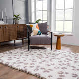 Living room scene with a Zhen Pink Spots Leopard Rug, gray chair, wood cabinet, and natural light. Roomscene-Rectangle