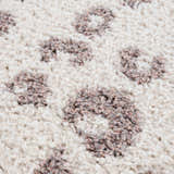 Close-up of the Zhen Pink Spots Leopard Rug showing the shag texture and pink and brown leopard spot pattern on off-white. Texture