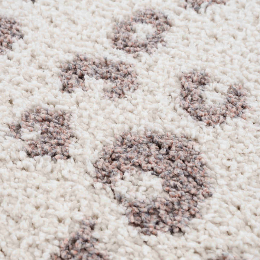 Close-up of the Zhen Pink Spots Leopard Rug showing the shag texture and pink and brown leopard spot pattern on off-white. Texture