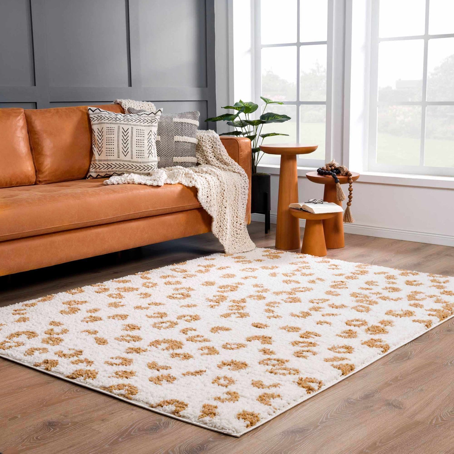 Living room scene with a white and yellow Altin Area Rug, leather couch, and wooden side tables. Roomscene-Rectangle