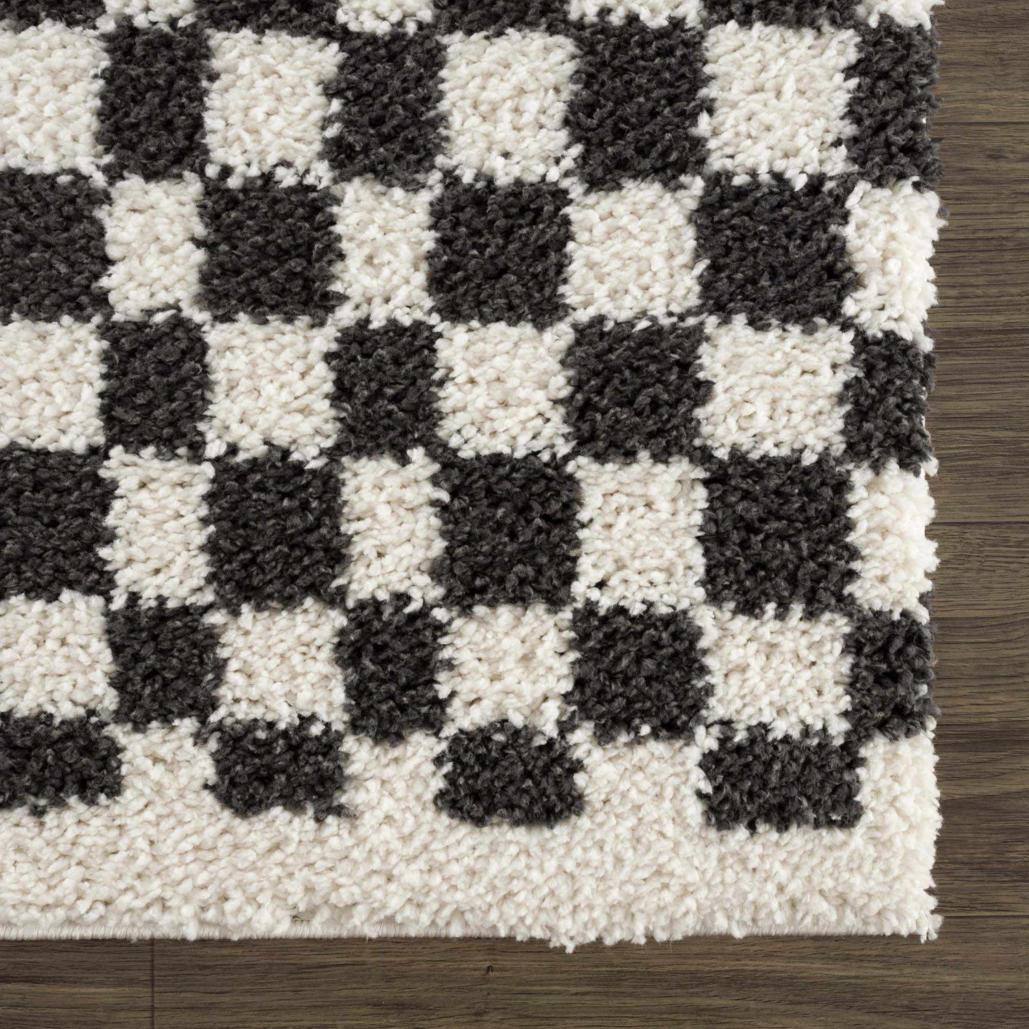 Close-up of the Kieu Black & White Checkered Shag Rug. Features a charcoal and off-white checkered pattern and shag texture. Swatch