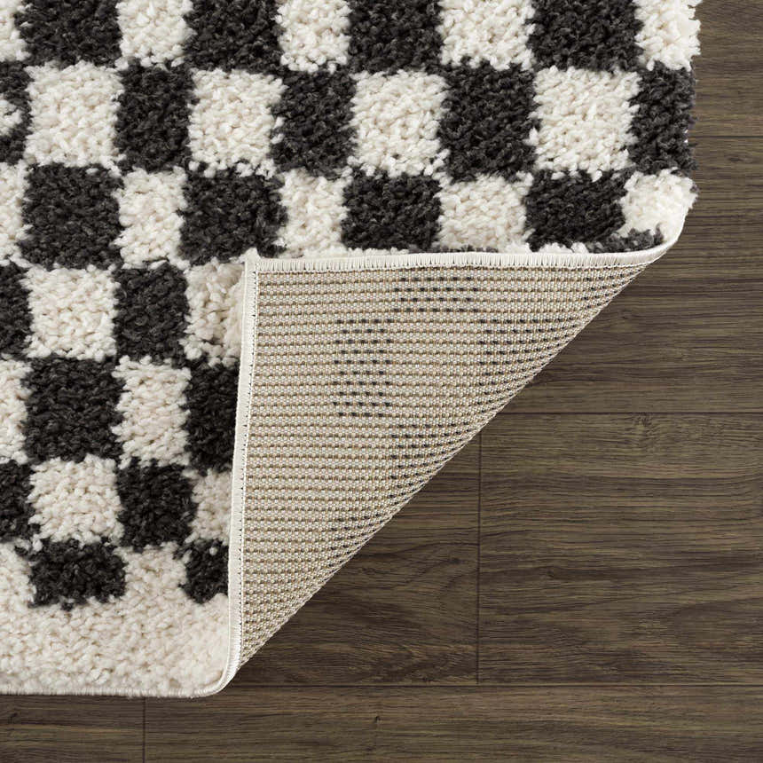 Close-up of the Kieu Black & White Checkered Shag Rug showing its fluffy texture and geometric checkered pattern. Fold