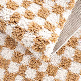 Close-up of the Kieu Mustard & Ivory Checkered Area Rug showing the shag texture, checkered pattern, and rug backing. Fold