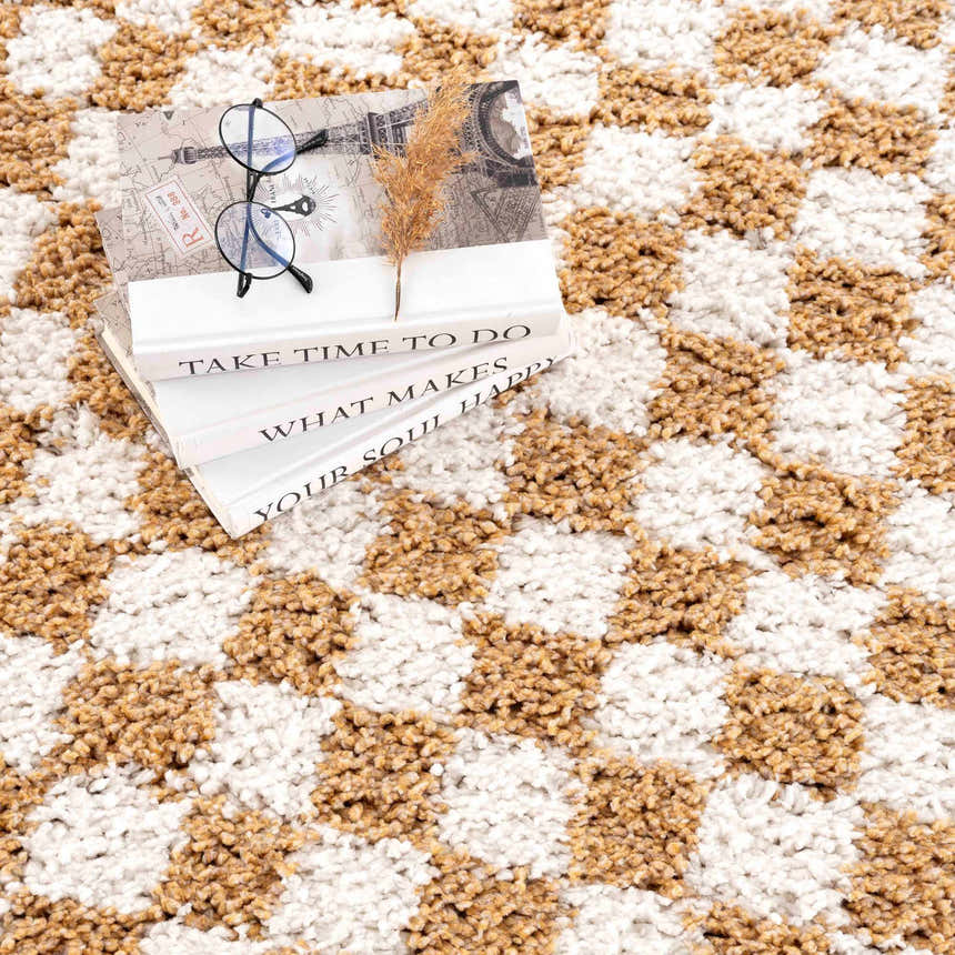 Close-up of the Kieu Mustard & Ivory Checkered Area Rug, a shag rug with a geometric checkerboard pattern. Styleshot