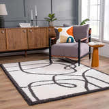 Living room scene with a Brad Area Rug, gray chair, wood cabinet, and modern decor. Roomscene-Rectangle