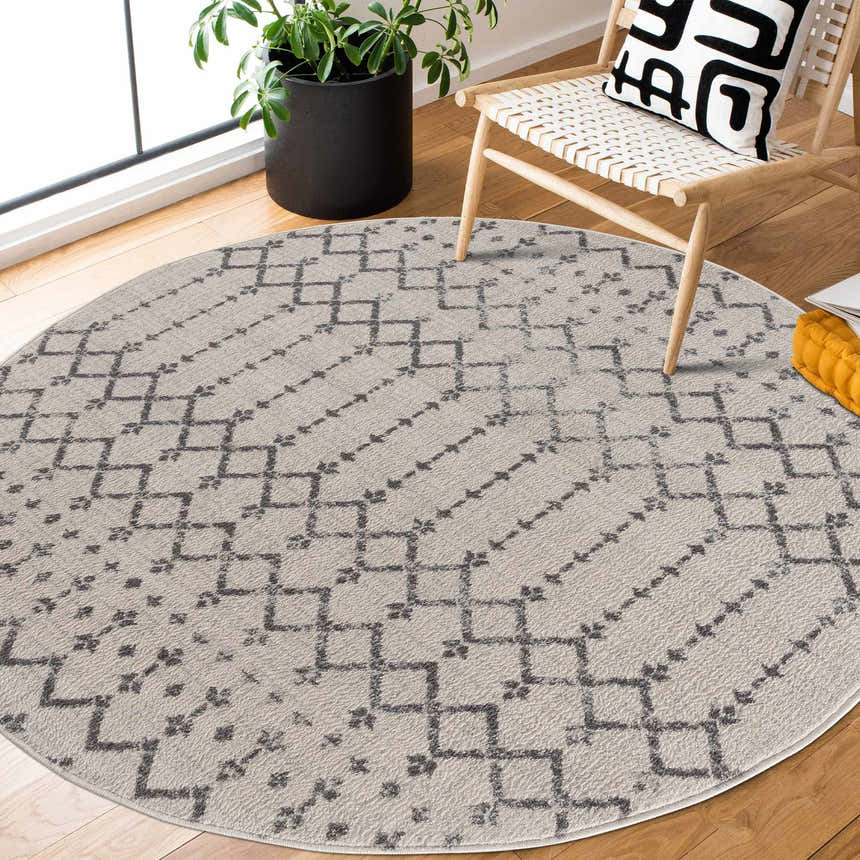Entryway with round Tigri Aztec 2310 Ivory Rug, wood chair, and potted plant. Bohemian style. Roomscene-Round