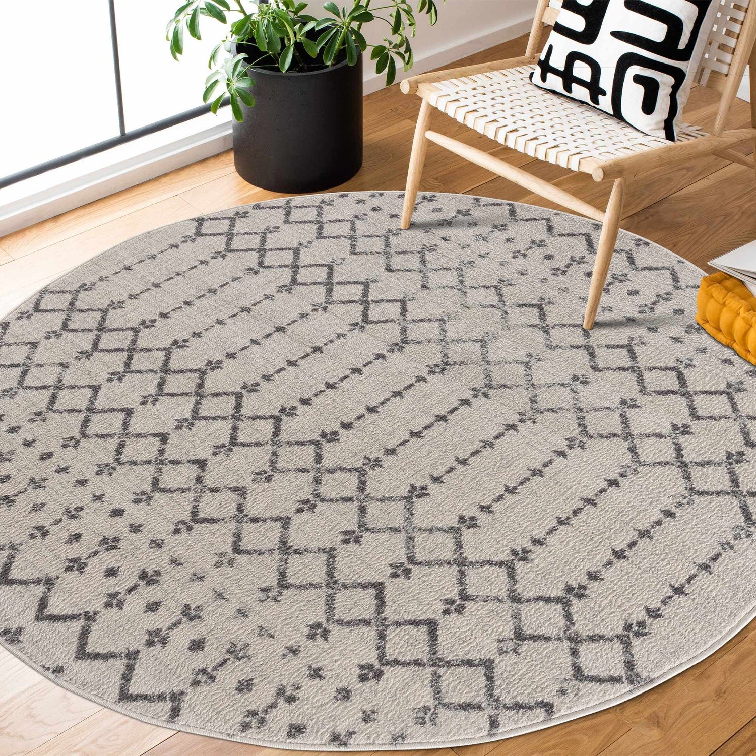 Entryway with round Tigri Aztec 2310 Ivory Rug, wood chair, and potted plant. Bohemian style. Roomscene-Round