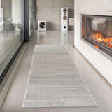 Modern living room with Tigri Aztec Ivory & Gray rug runner, fireplace, and speakers. Concrete walls and floors. Roomscene-Runner