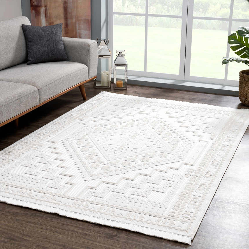 Living room scene with a gray sofa and Ivory Alya 3D Medallion Fringe Area Rug on a dark wood floor. Roomscene-Rectangle