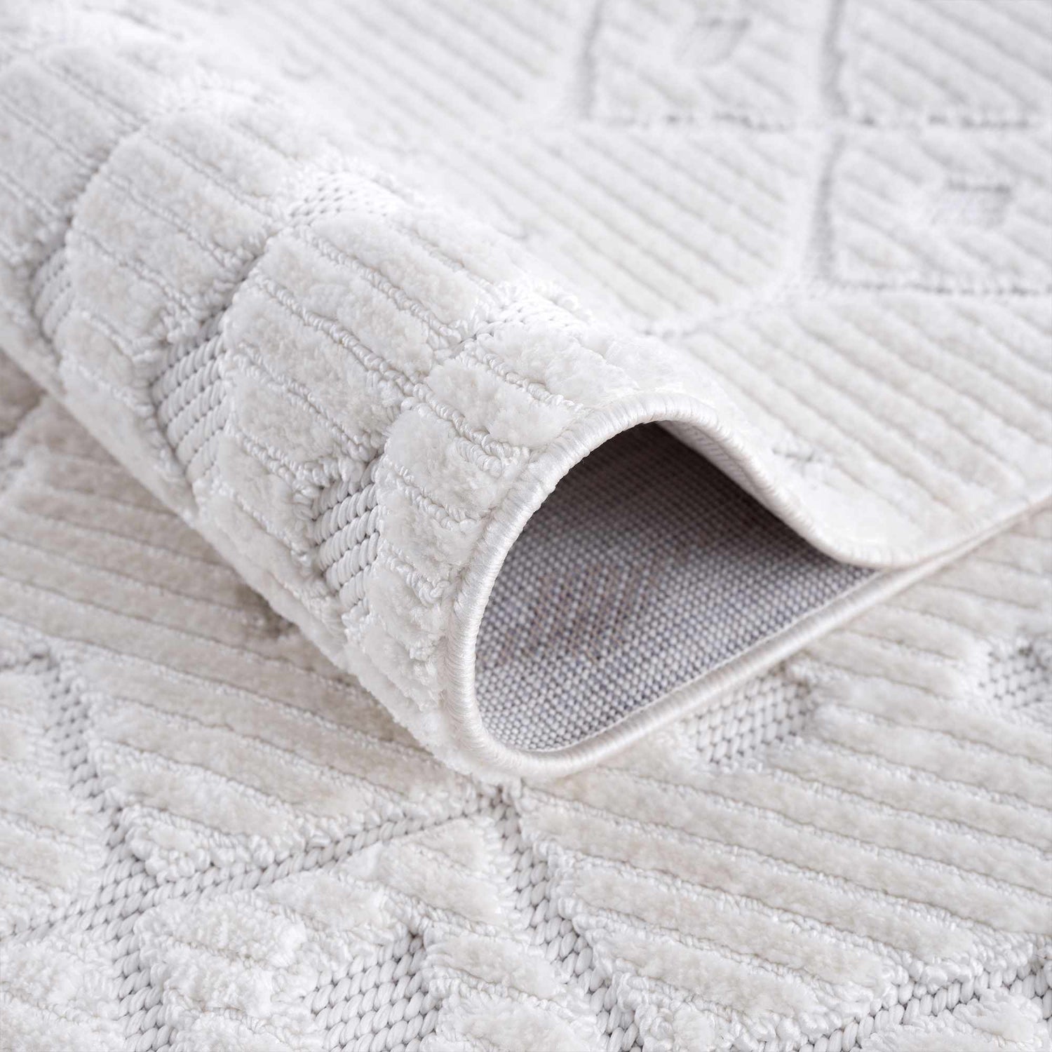 Close-up of the Ivory Beil 3D Fringe Area Rug, showing its geometric pattern, fringe texture, and soft ivory color. Fold