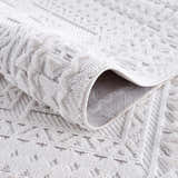 Close-up of the Ivory Alya 3D Medallion Fringe Area Rug showing the textured, geometric pattern and soft white color. Fold