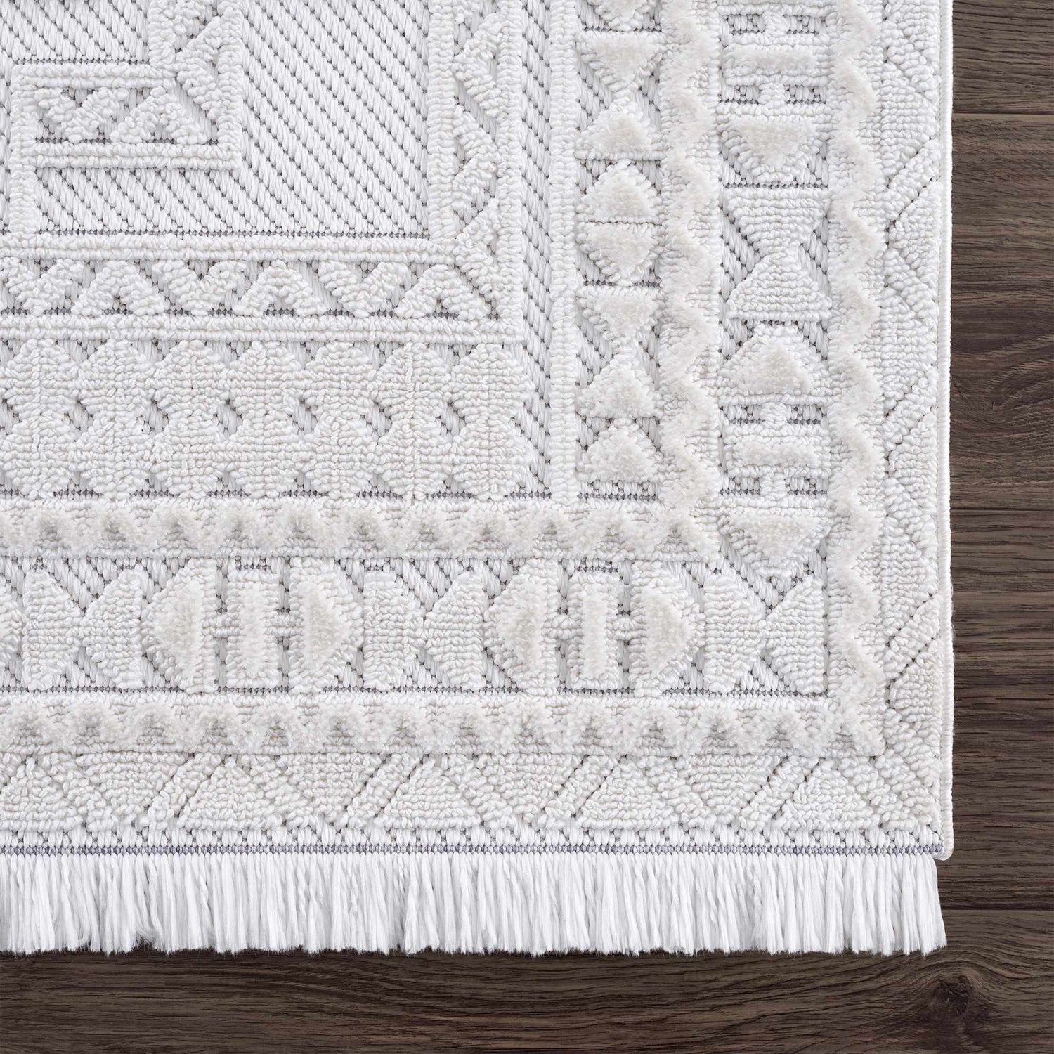 Close up of the Ivory Alya 3D Medallion Fringe Area Rug showing the texture and geometric pattern. Swatch