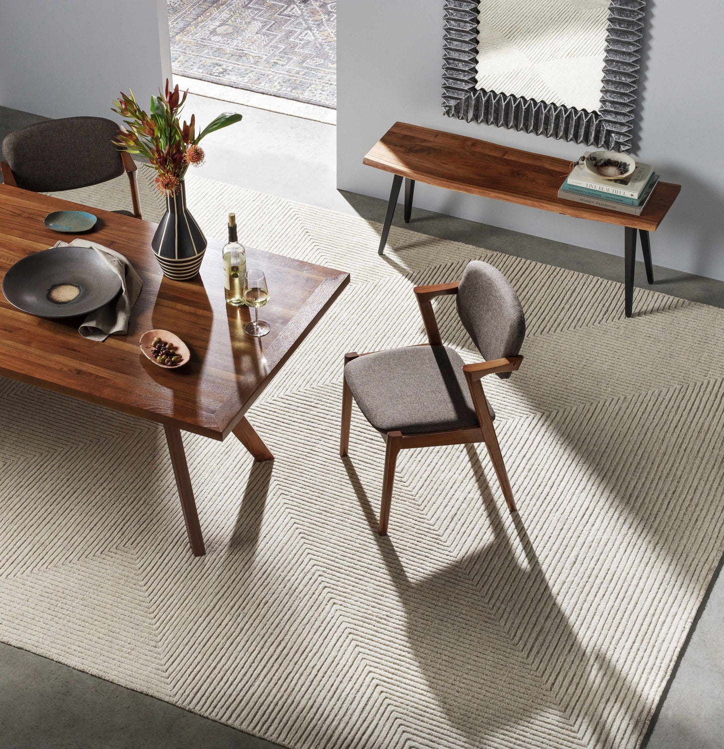 Dining room scene with a beige Metcalf Area Rug, wood table, and modern decor. Styleshot
