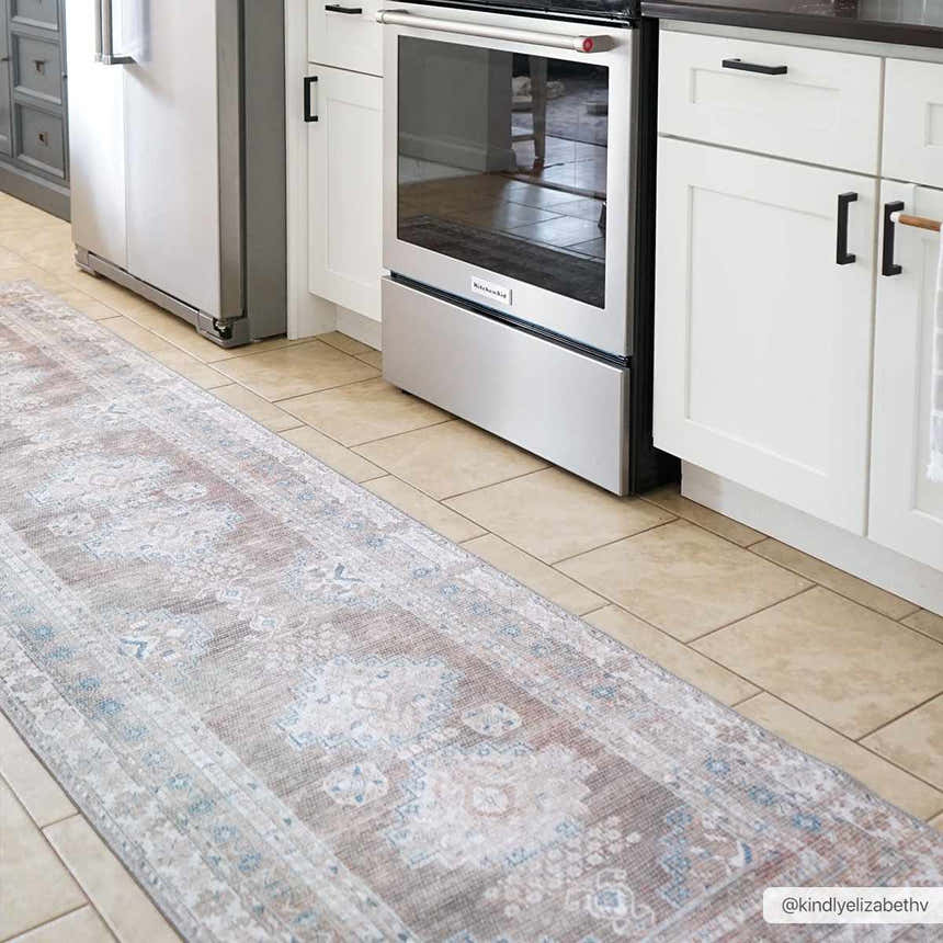 Kitchen scene with a Baltinglass Flat Pile Washable Rug runner in blue, cream, and beige. White cabinets and stainless steel appliances. Roomscene-Runner