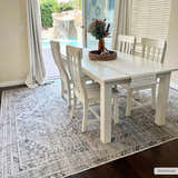 Dining room with white table and Barny Beige Flat Pile Washable Rug. Waterfall feature visible through sliding glass doors. Roomscene-Rectangle