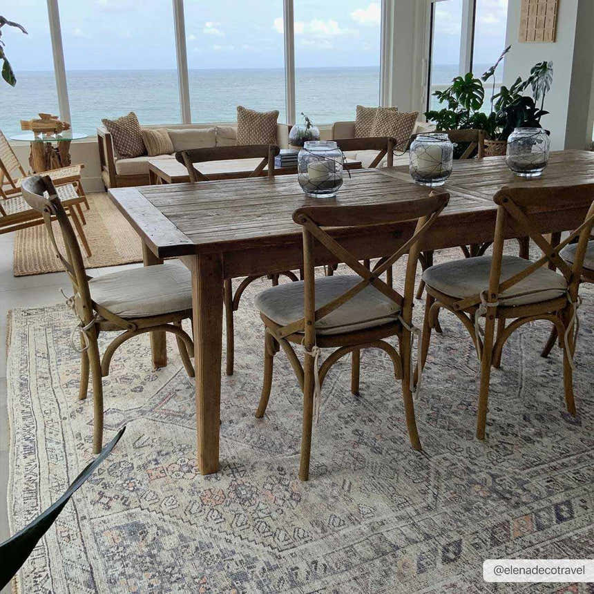 Coastal dining room with a rustic wood table and the Barny Tan Washable Area Rug in black, gray, and peach tones. Roomscene-Rectangle