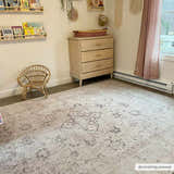 Nursery room scene with a beige Bethany Vintage Flat Pile Washable Rug, dresser, and rattan chair. Roomscene-Rectangle